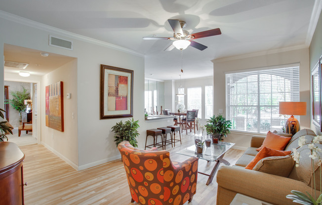 View of Living Room with Plank-Wood Flooring, Ceiling Fan, and View of Bedroom at Raveneaux Apartments