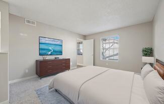 A bedroom with a large bed and a painting on the wall.