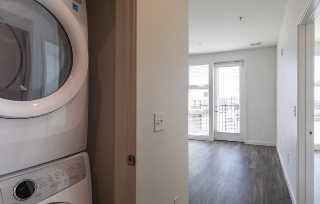 a laundry room with a washer and dryer and a door to a balcony