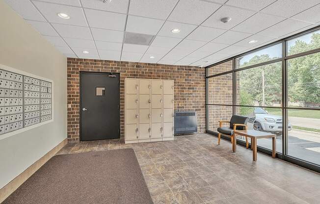 a lockers room with a desk and a chair in a building with large windows