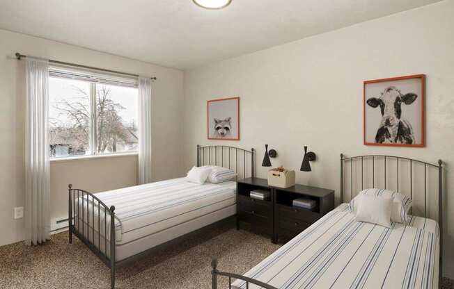 A bedroom with two beds, one with a striped bedspread.