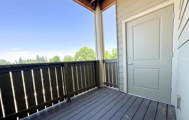 a balcony with a white door and a view of trees