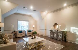 A bright sitting room with modern decor, armchairs, and a coffee table.