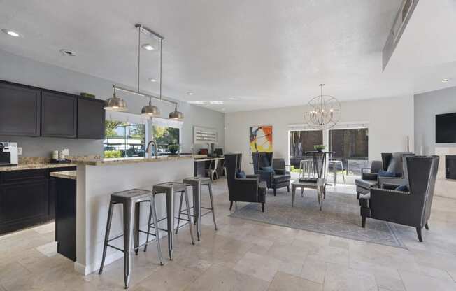 a kitchen with a bar and a living room with a table and chairs