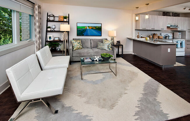 A living room with a white couch and a glass coffee table.