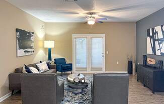 a living room with couches and a ceiling fan