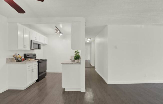 a kitchen with white cabinets and a counter top at Willow Tree Apartments, Torrance, CA