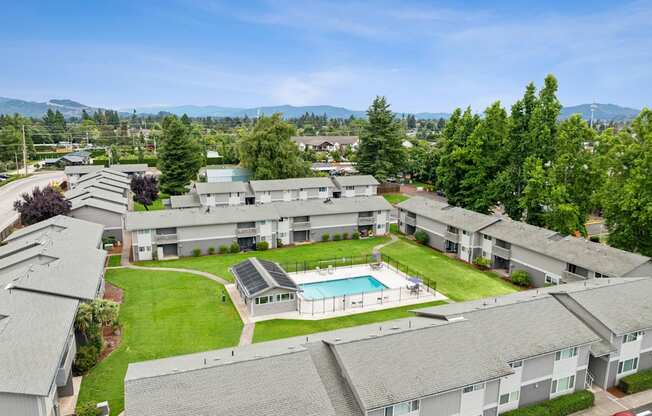 Apartment complex with a pool and green lawns.