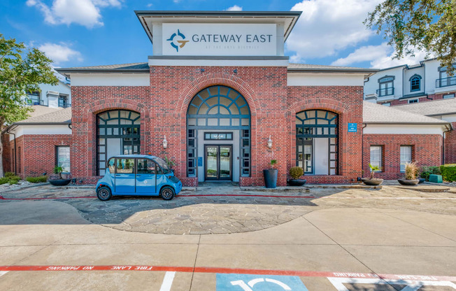 the exterior of the gateway east building with a blue car parked in front of it