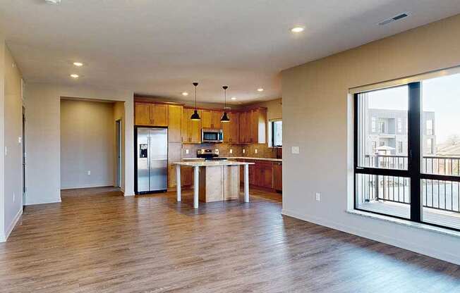 a spacious living room with a kitchen in the background