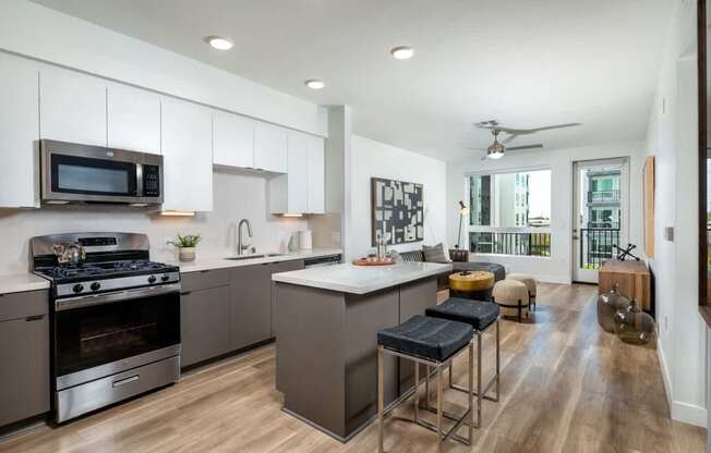 A modern kitchen with a stove, oven, and bar stools.