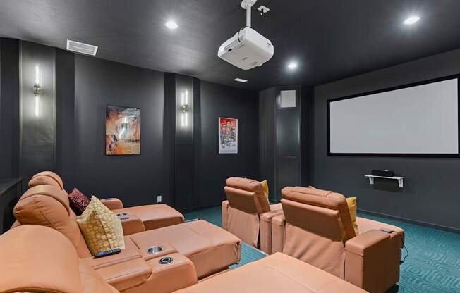 A home theater with orange couches and a large screen.