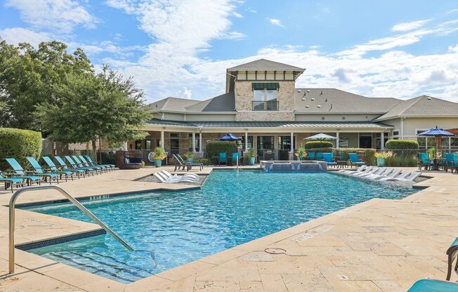 A large swimming pool with a building in the background.