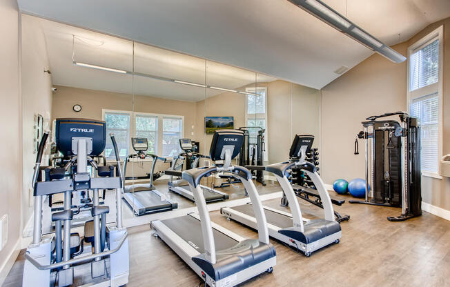 Lake Oswego Apartments - Westlake Meadows - Stunning Fitness Center With a Mirror Wall, Treadmills, an Elliptical, and Other Exercise Equipment