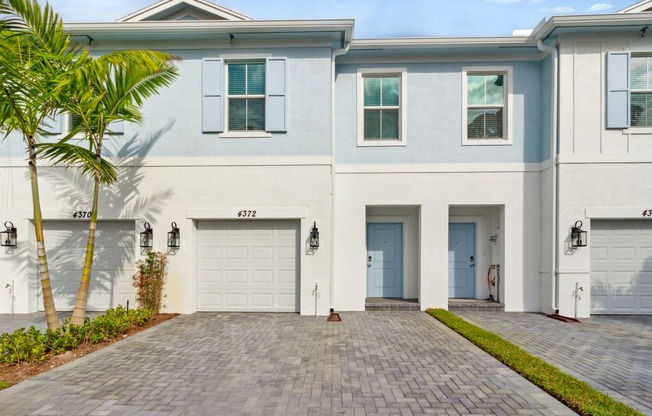 Boatman Hammock Townhomes in Lake Worth, FL photo of  a white house with two garage doors and a driveway