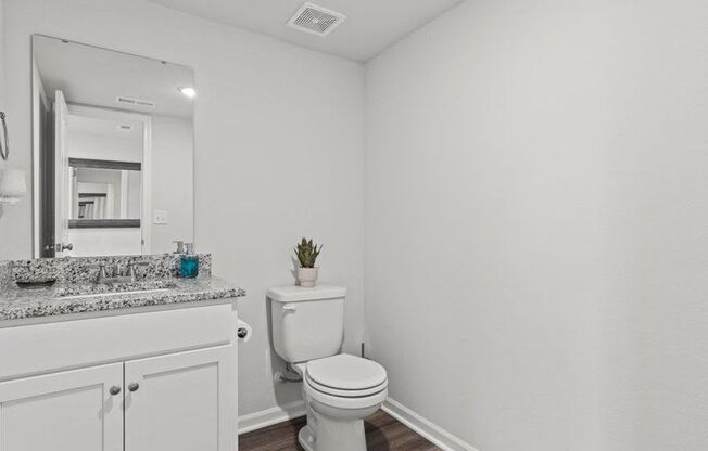 a white bathroom with a toilet and a sink