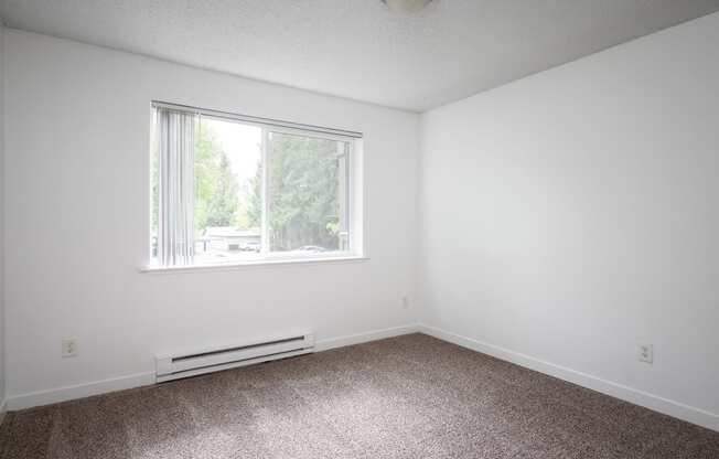 an empty room with carpet and a window