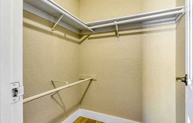 a walk in closet with white walls and a white door