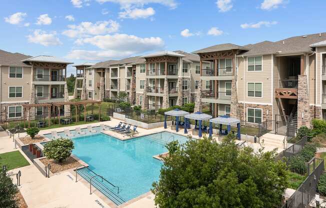 a swimming pool with an apartment building in the background