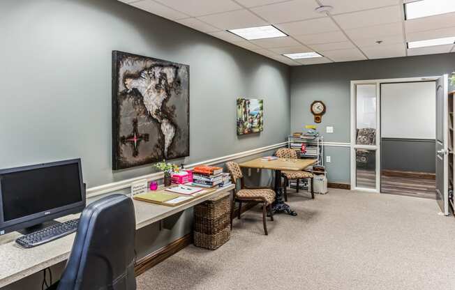 an office with two desks and a computer and a map on the wall