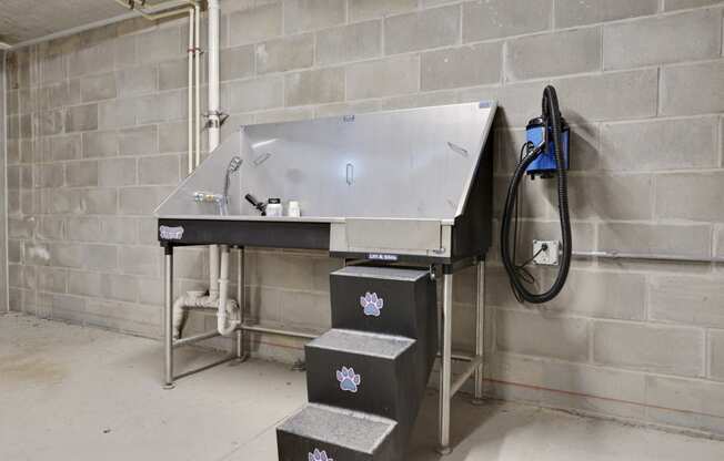 a large metal sink in a room next to a brick wall