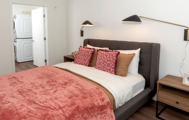 a bedroom with a bed and a washer and dryer