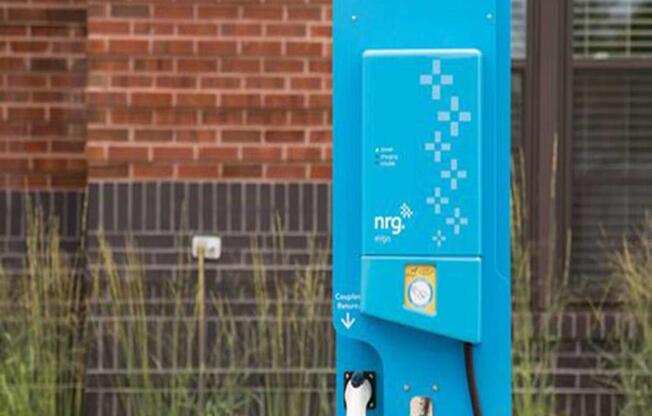 a blue parking meter in front of a brick building