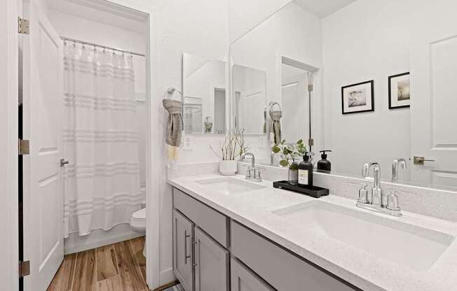 A bathroom with a white sink and a white shower curtain.