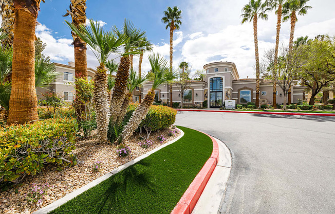 a building with palm trees and a street in front of it