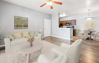 A living room with a white couch, a coffee table, and a ceiling fan.