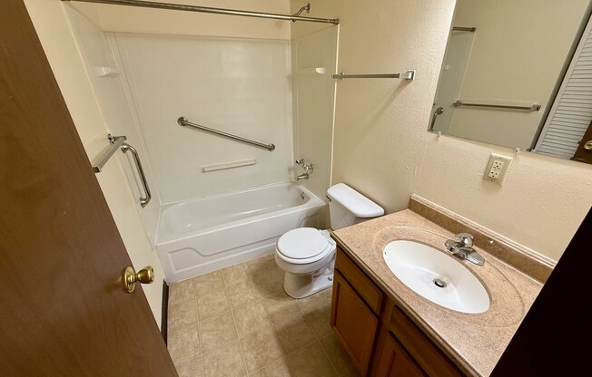 A bathroom with a toilet, sink, and bathtub.