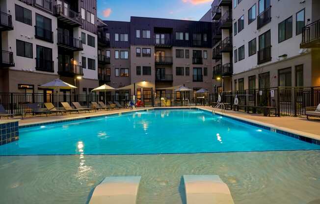 a large swimming pool in front of an apartment building