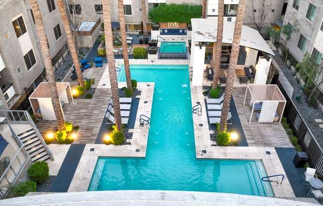 A swimming pool surrounded by palm trees and buildings.