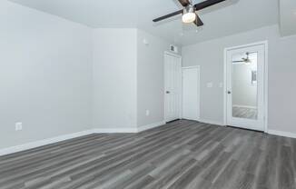 the living room of an empty house with a ceiling fan