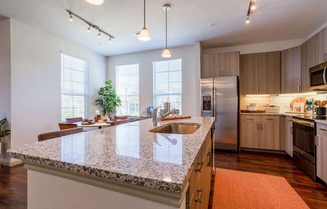 A kitchen with a granite countertop and stainless steel appliances.