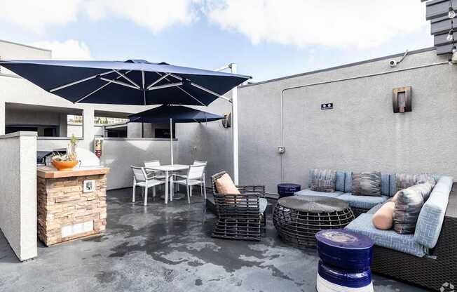 A patio with a table, chairs, and a sofa.