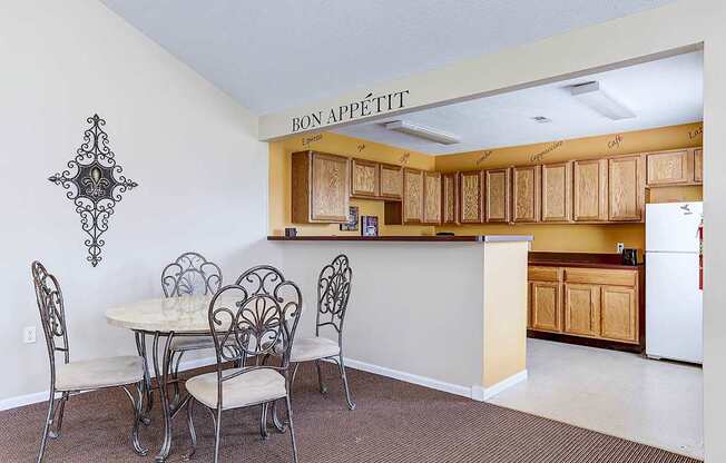 A kitchen with a table and chairs under a sign that says Bon Appetit.
