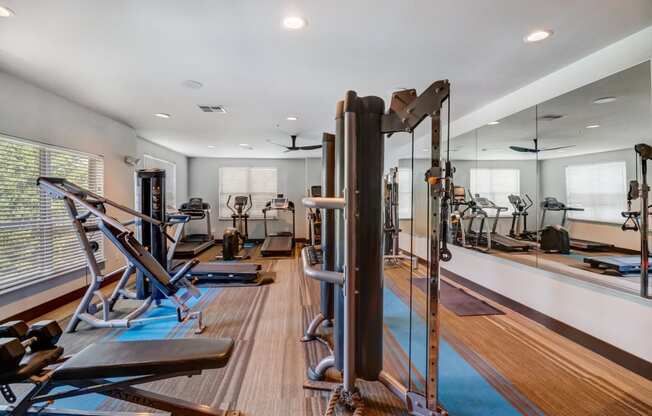 Community gym with cardio equipment and mirrors on the wall