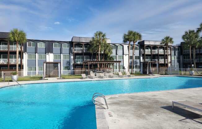 a large swimming pool in front of an apartment building