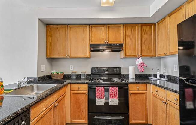A kitchen with wooden cabinets and black appliances.