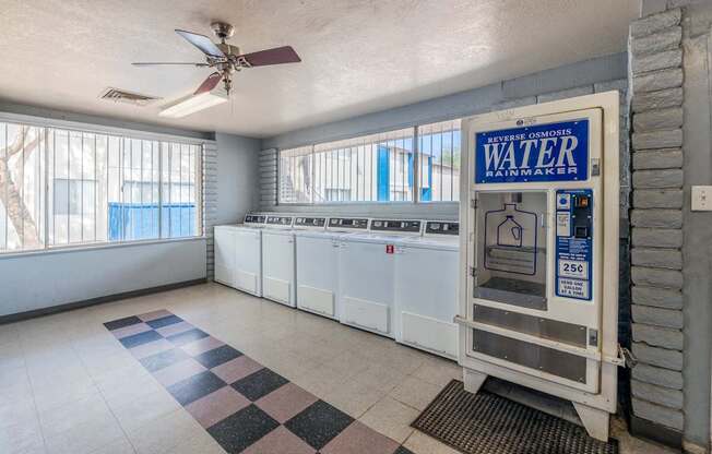 A room with a water heater and a ceiling fan.