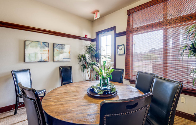 a dining room with a wooden table and leather chairs