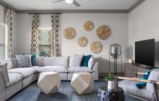 A living room with a white sofa, a grey armchair, and a black coffee table.