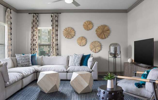 A living room with a white sofa, a grey armchair, and a black coffee table.