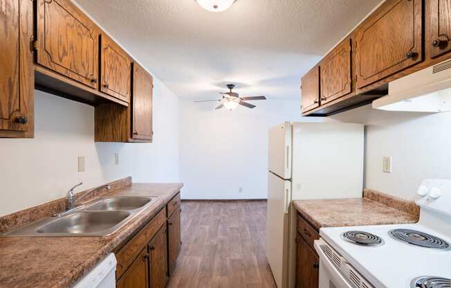 a kitchen with white appliances and wooden cabinets.  Eagan, MN Glen Pond Apartments