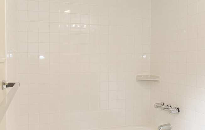 a white bathroom with a tub and a shower