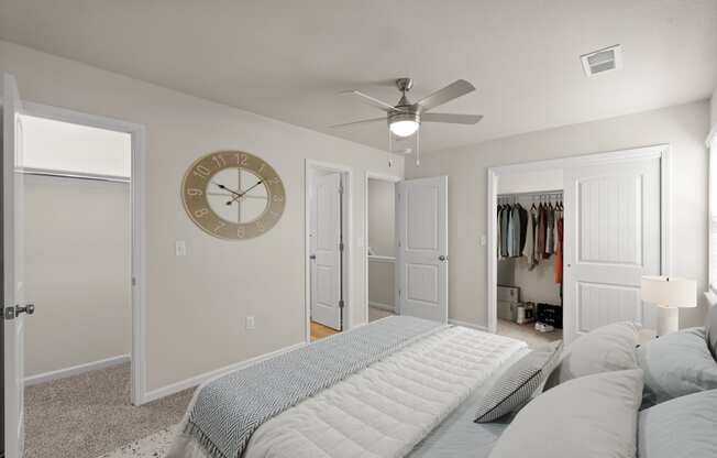 a bedroom with a large bed and a clock on the wall