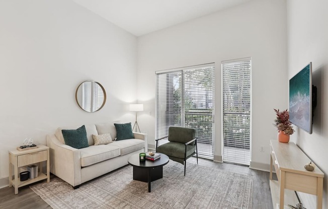 A living room with a couch, chair, and television.