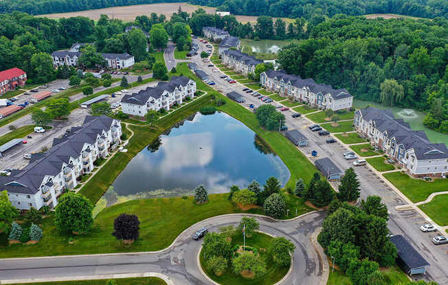 A bird's eye view of an apartment community with a pond in the middle at South Bridge Apartments, Fort Wayne, IN, 46816