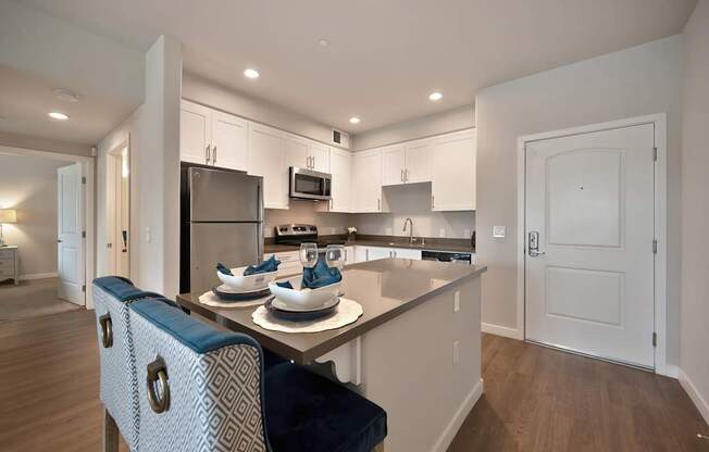 A modern kitchen with a dining table and chairs.